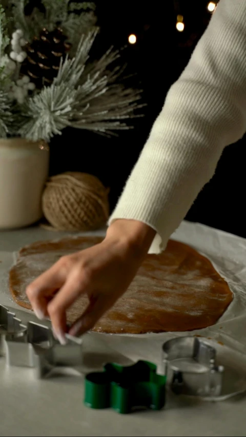 woman making pastry using cookie cutters on white counter