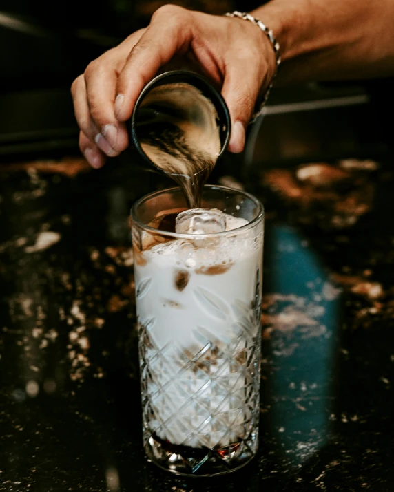 someone pouring an alcohol into their glass