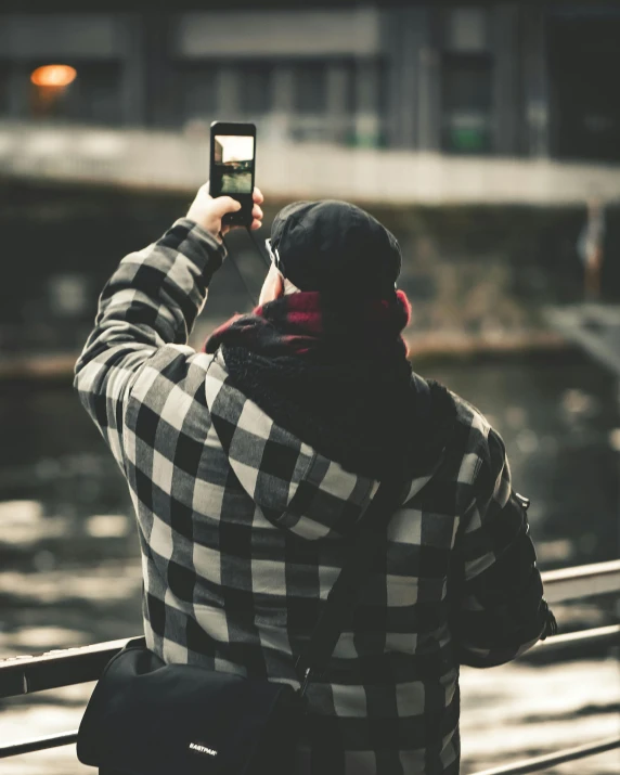 a person standing with a cell phone near a wall