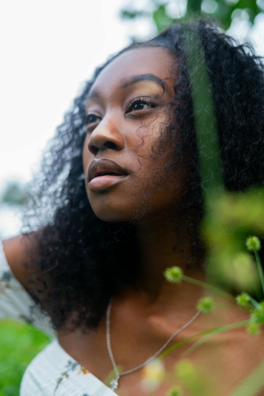 a woman standing in a field with her hair blowing