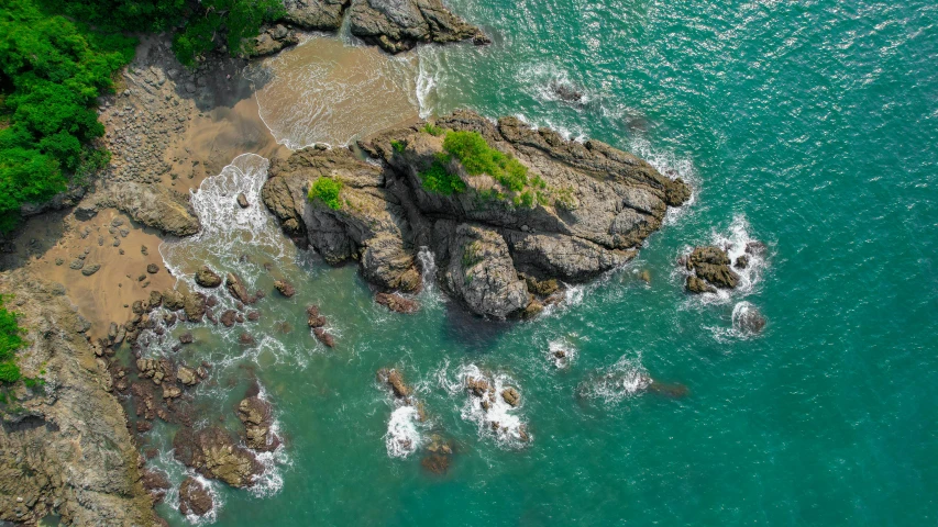 an overhead view of green ocean waves on the shore