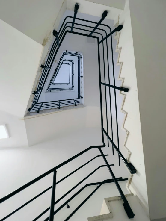 white staircase with black metal handrails running through it