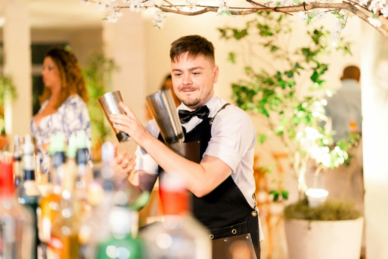 a man in a black tie pouring some drinks