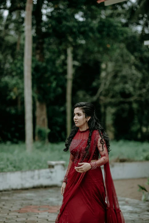 a woman in red and maroon outfit walking around