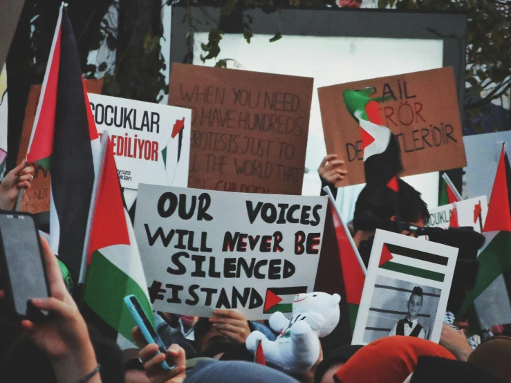 a large crowd of people holding signs and talking