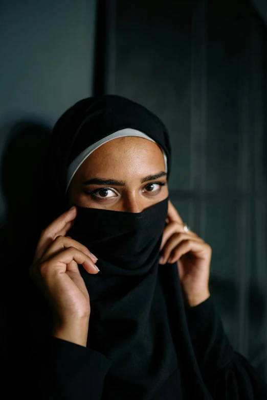 a woman with black hair is covering her face