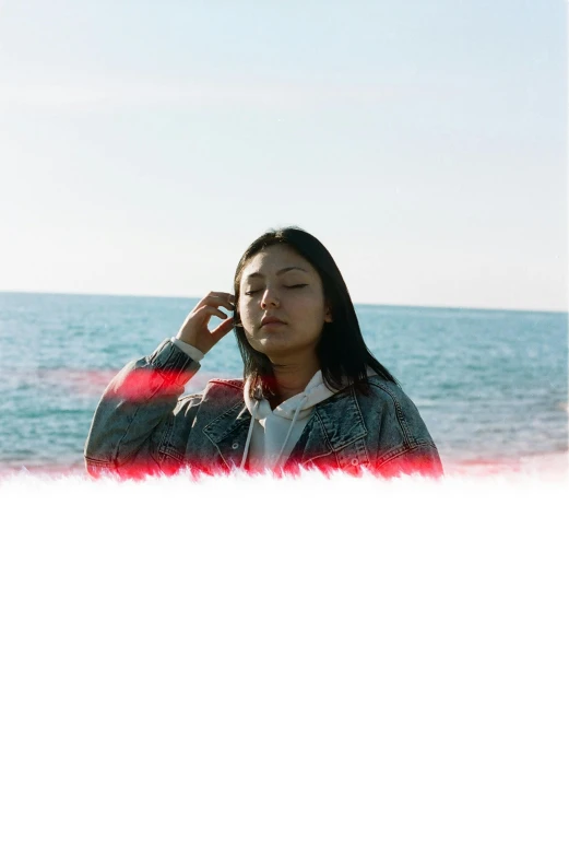 a woman is standing outside on the beach talking on her cellphone