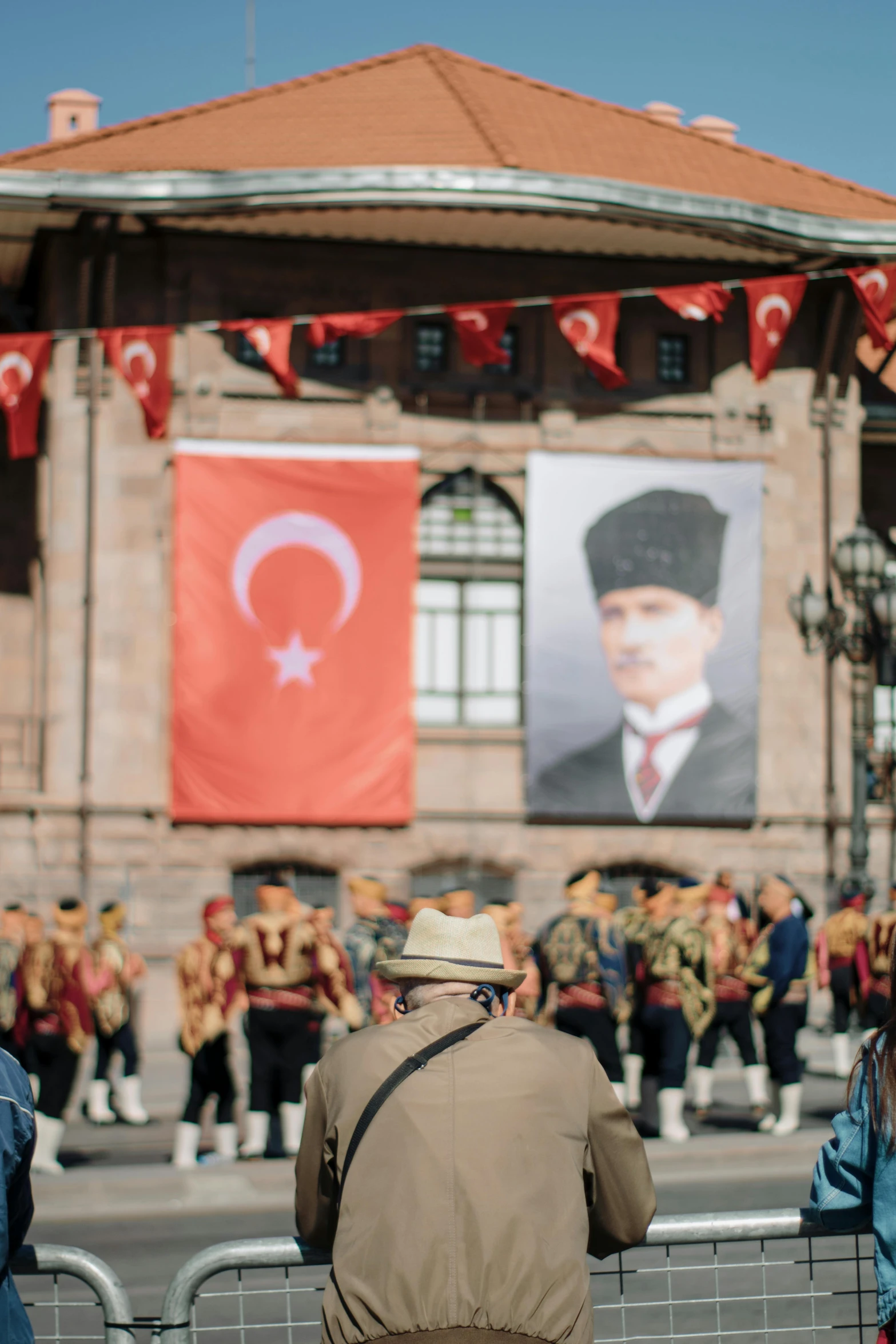 people watching soldiers perform in front of an image on a wall