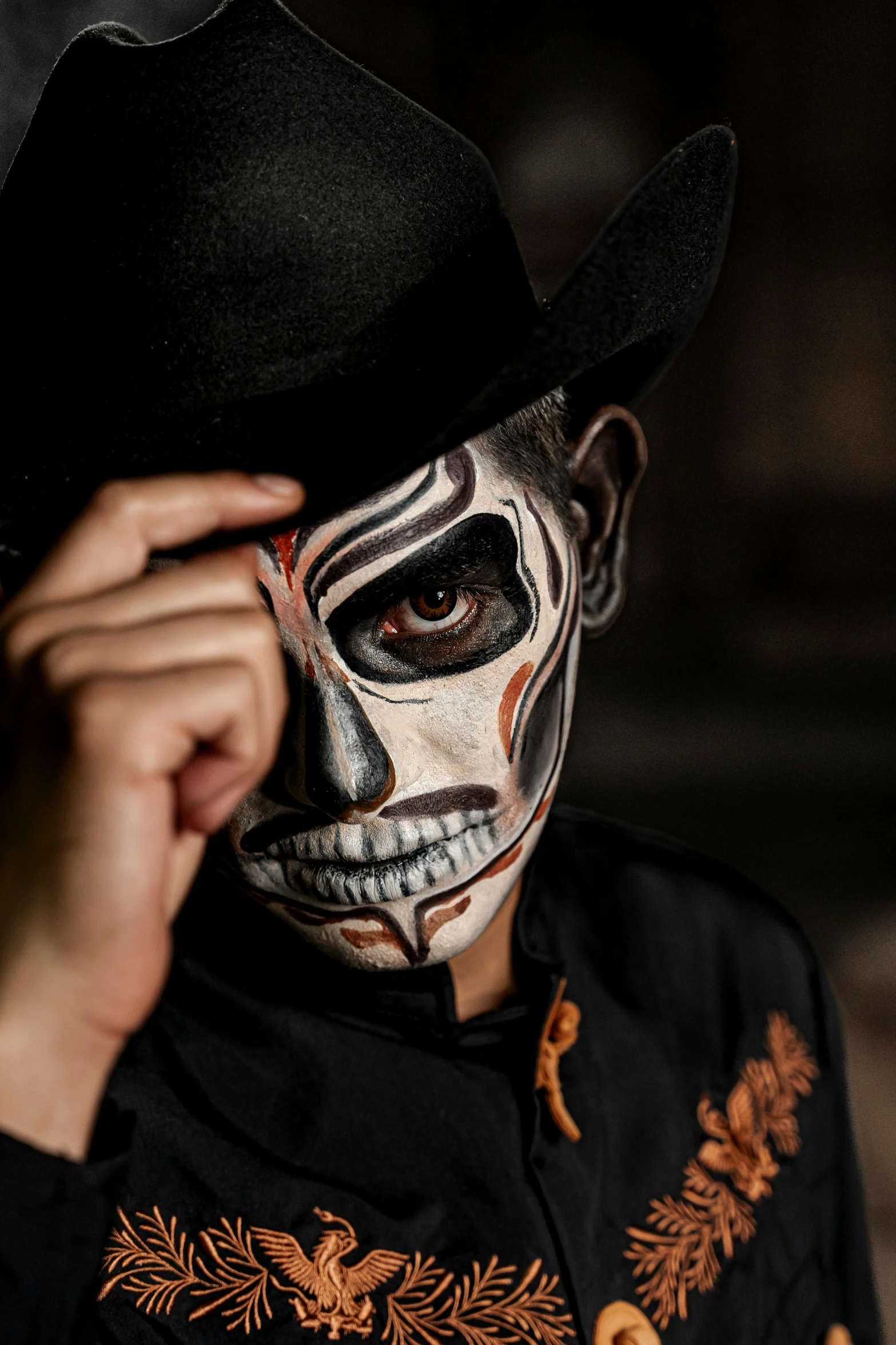 a man wearing a black top and white face painting