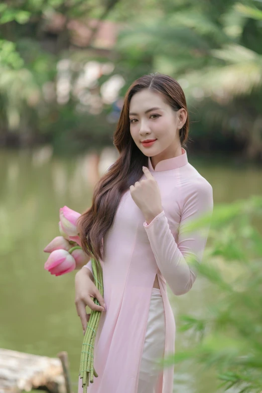 a woman standing on a wooden bridge holding tulips