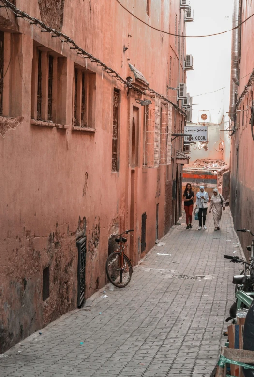 an alleyway with bicycles and red walls on it