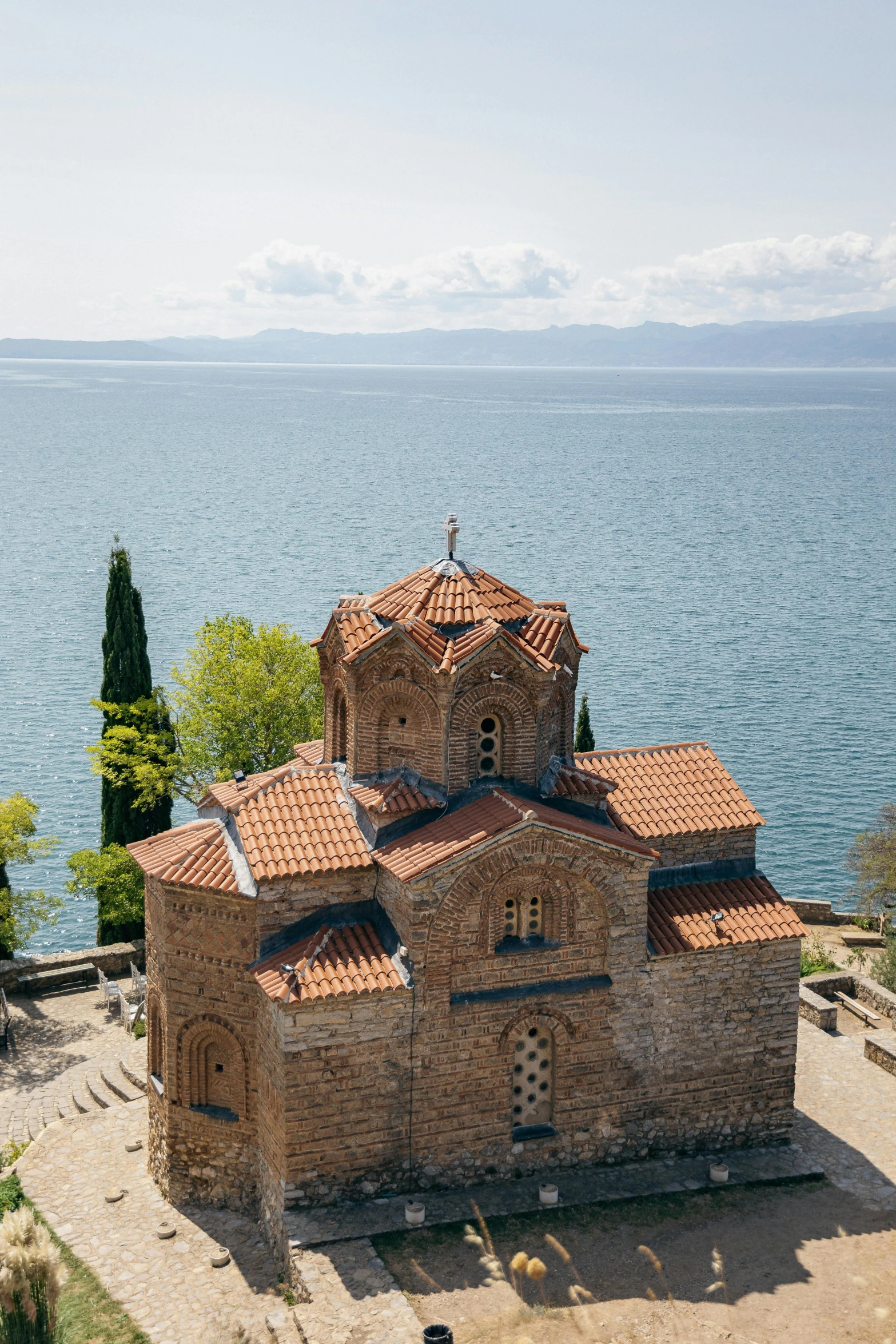 an old stone church with a body of water behind it