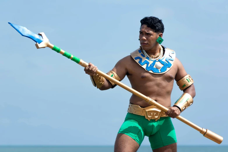 a person is standing on a beach with a spear and mask