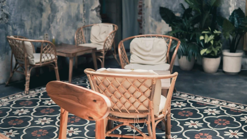 an outdoor living room with wicker chairs and a patterned carpet