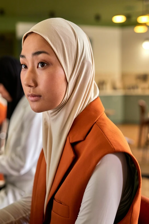 an image of a woman wearing hijab sitting in front of two computers