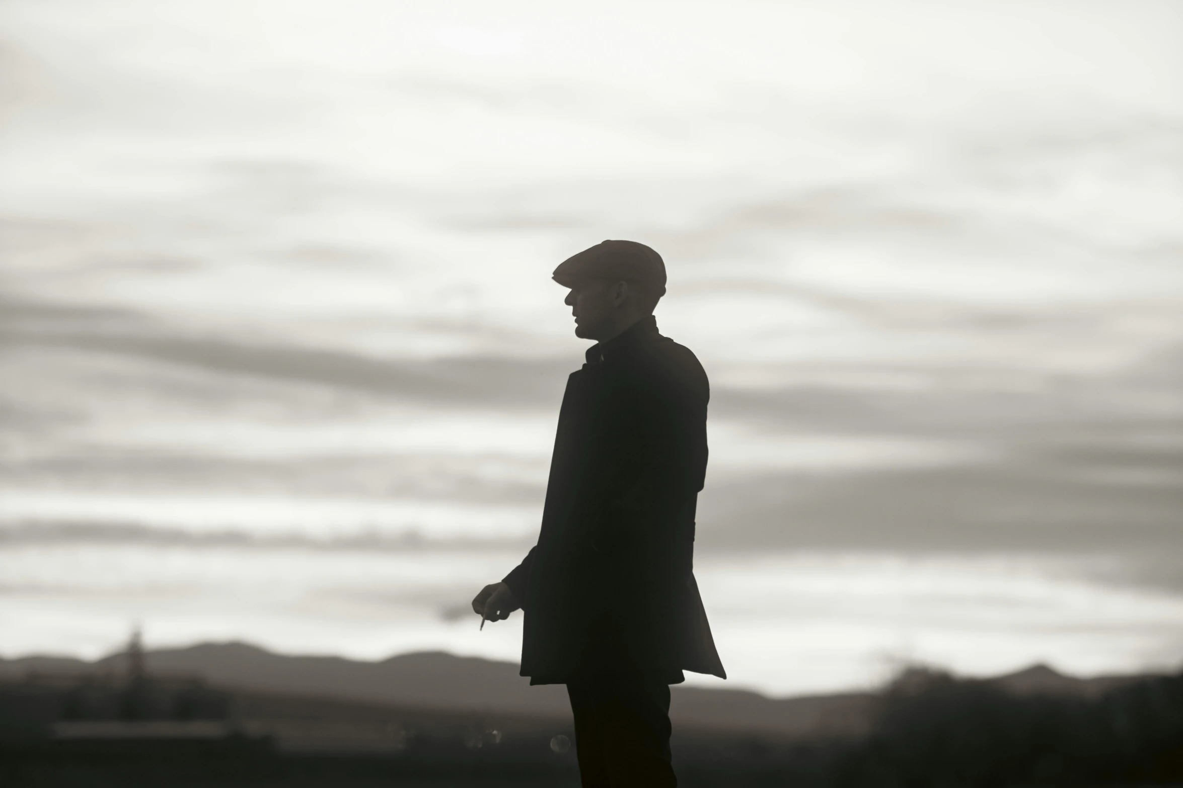 man standing with hat on his head, in silhouette
