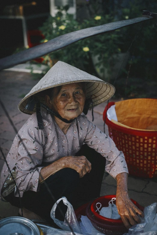 an elderly lady wearing a white hat and holding an umbrella