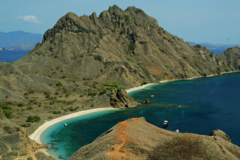 an island with some blue water and sand around it