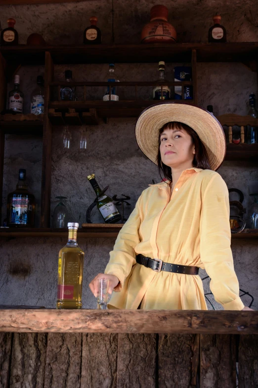 woman sitting at bar in yellow robe and cowboy hat