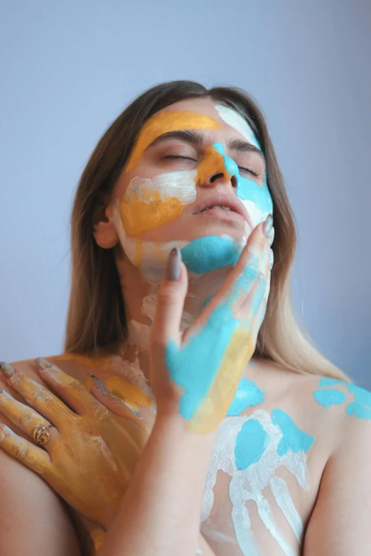 woman with painted body and hands holding hand to her mouth