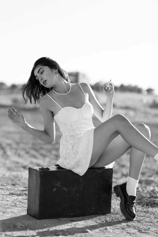 a woman posing in a white dress and tie