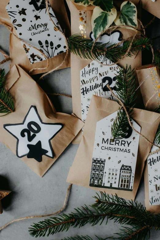 a table with presents wrapped in brown paper and evergreen nches