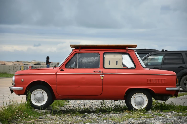 an orange car with a yellow top and a black car in the back