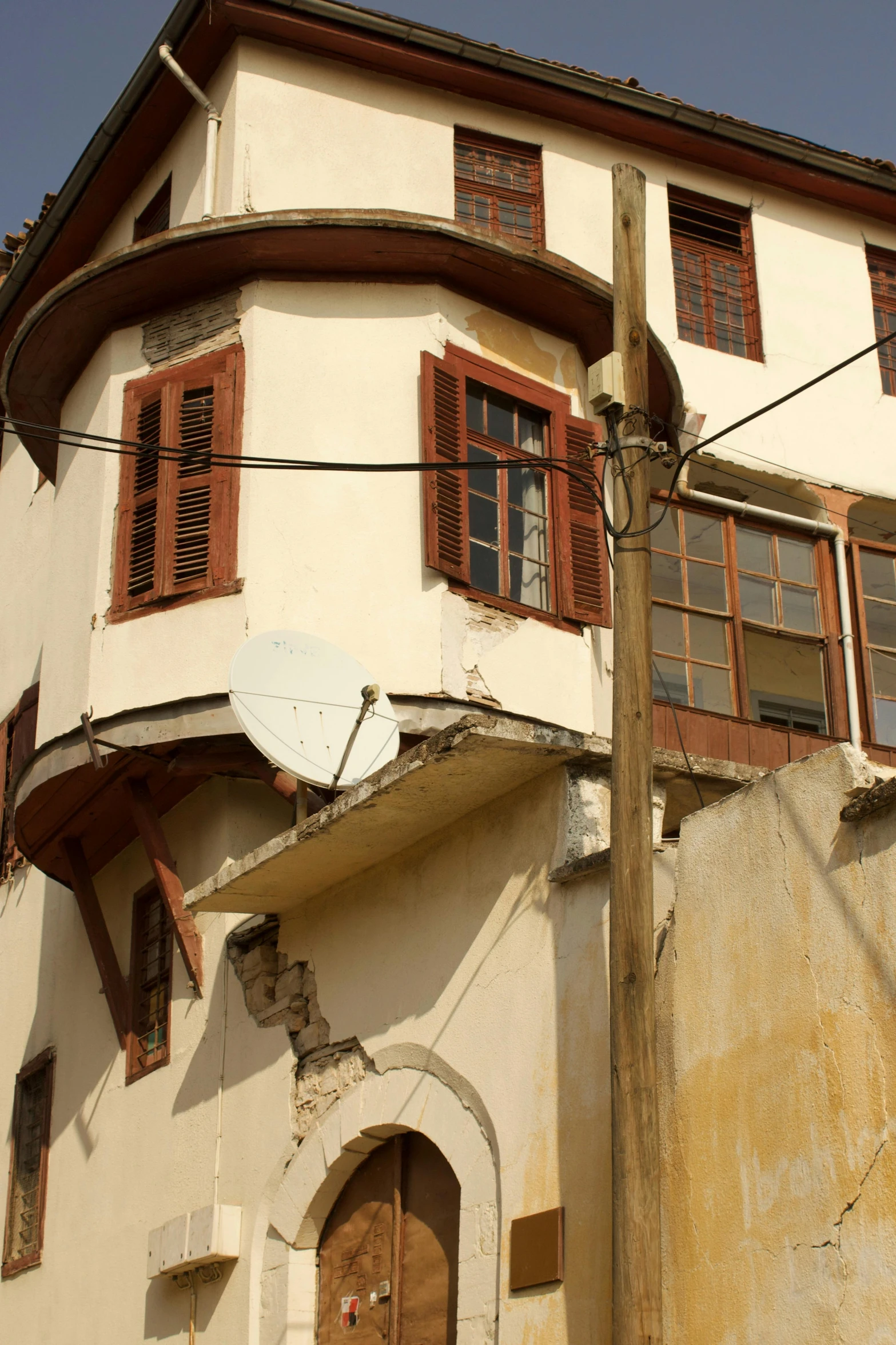 a large white building with red shutters and wooden window panes