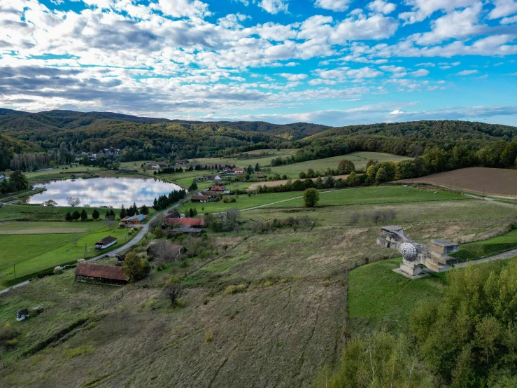 a rural area that includes a lake, forest and lots of grass