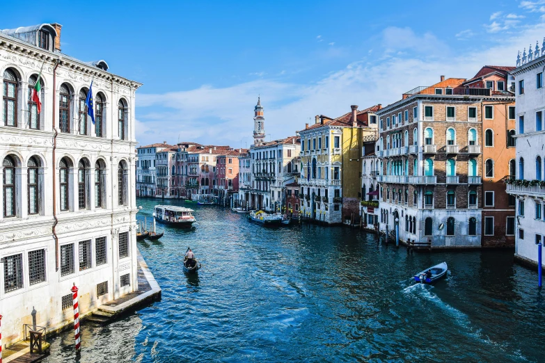 the buildings are along a narrow river with boats