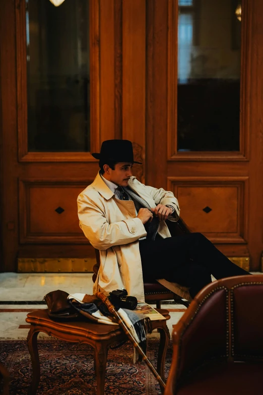 a man sits wearing a white coat and tie