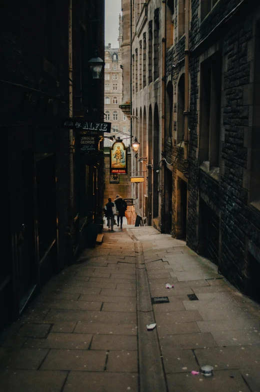 an alley in a city area with people walking by