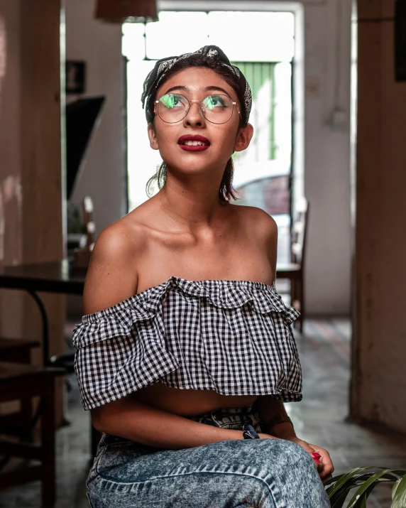 a woman wearing glasses sitting on a counter