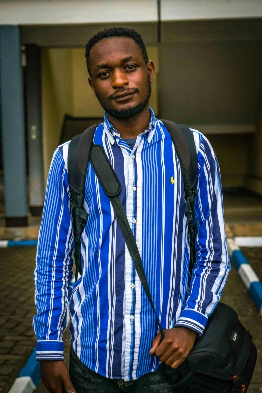 an african american male posing for the camera with his bag