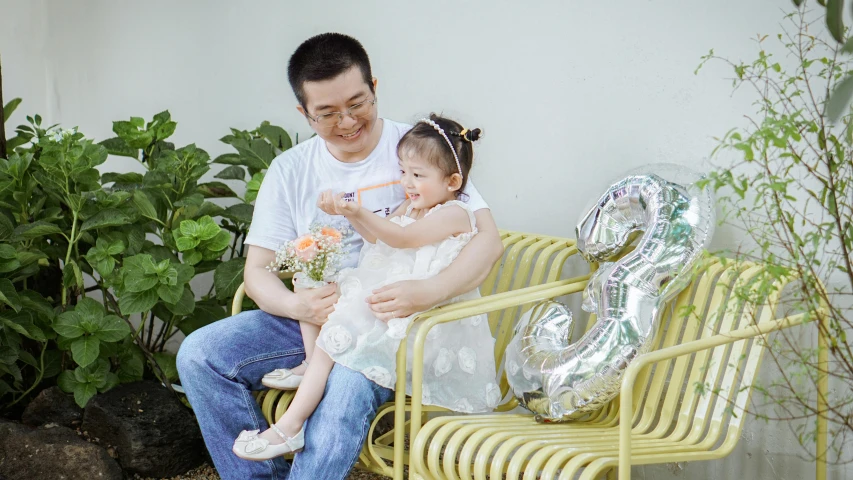 a father holding his child on a yellow bench