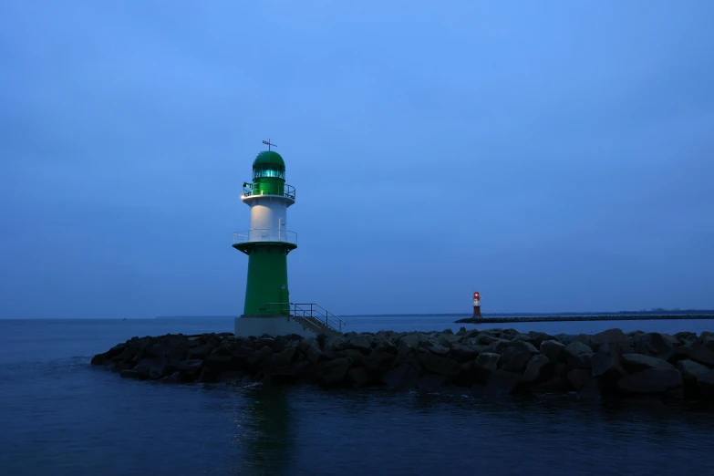 the light house is sitting on the rock formation at the beach