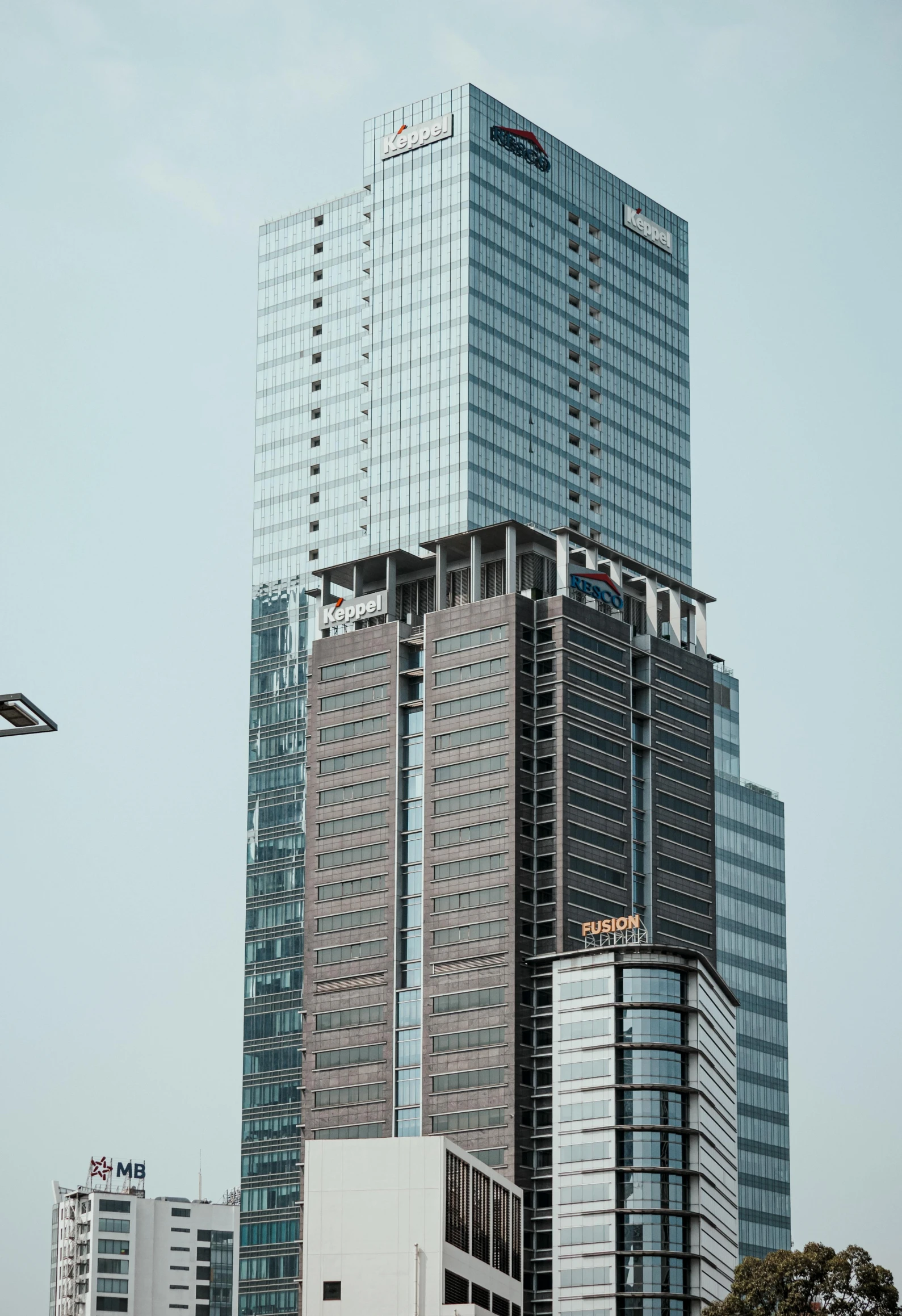 a plane flying over a tall building with trees on the side of it