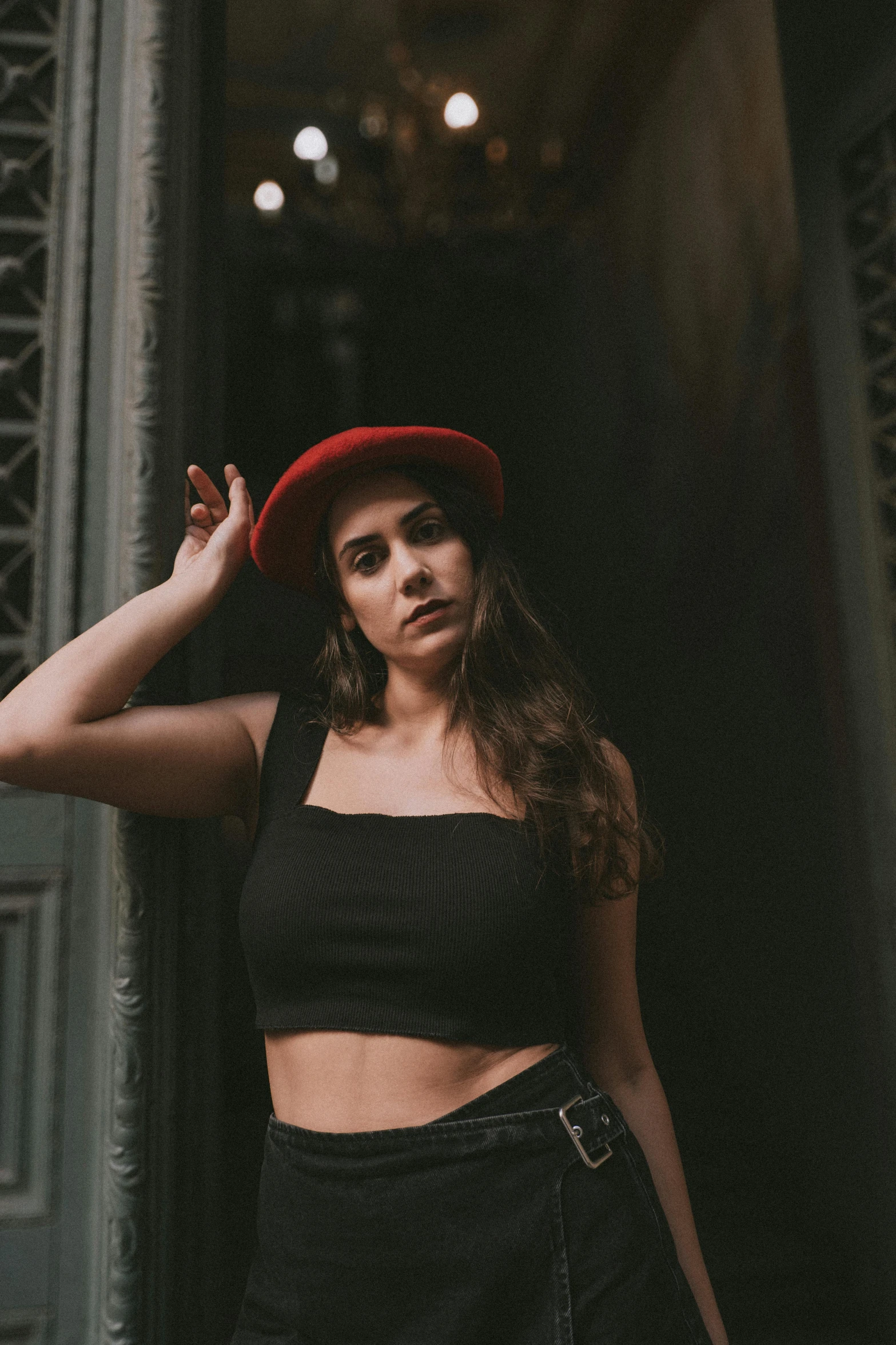 woman in crop top and black skirt wearing a red hat