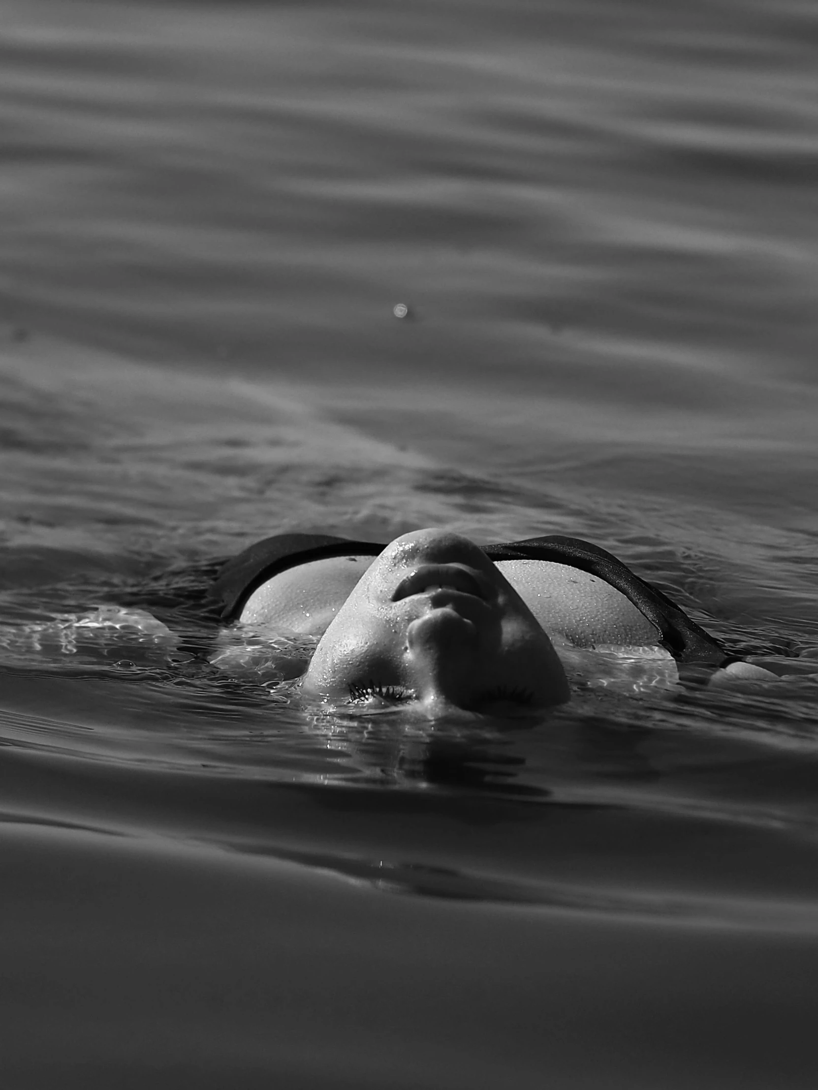 a woman is swimming in the ocean with one eye on the other