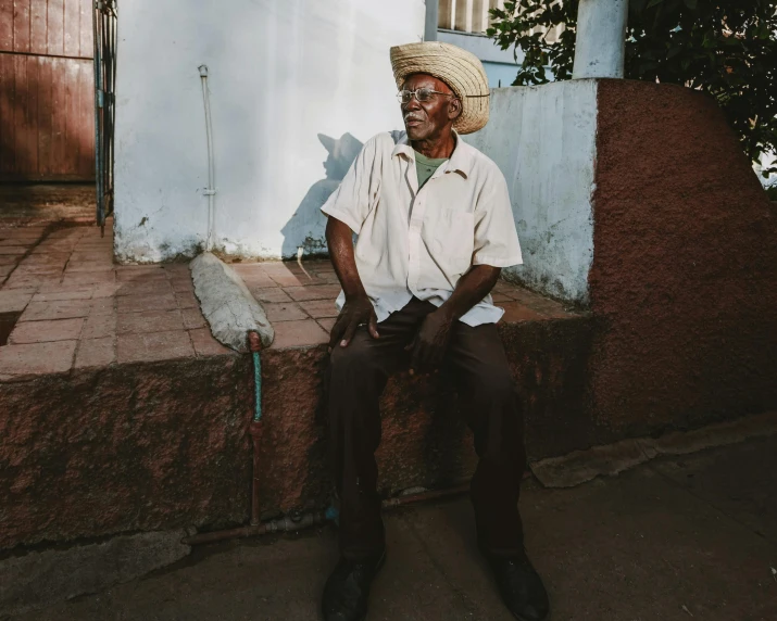 a man sitting in front of a white wall