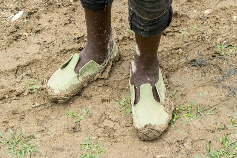 someone is stepping on muddy, dusty grass