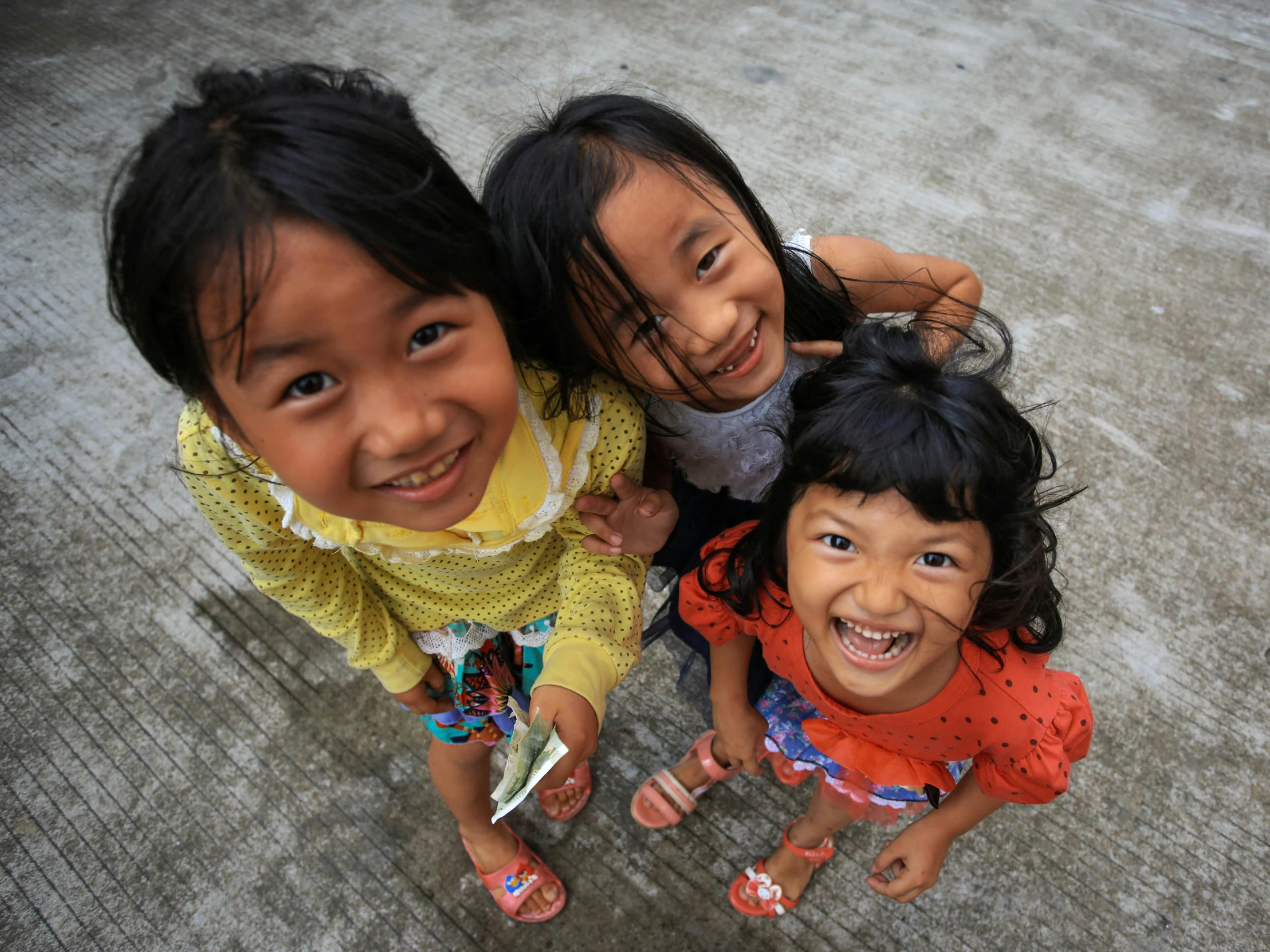 three young children posing for the camera, smiling