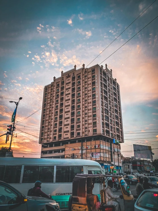 a tall building stands in the middle of a busy street