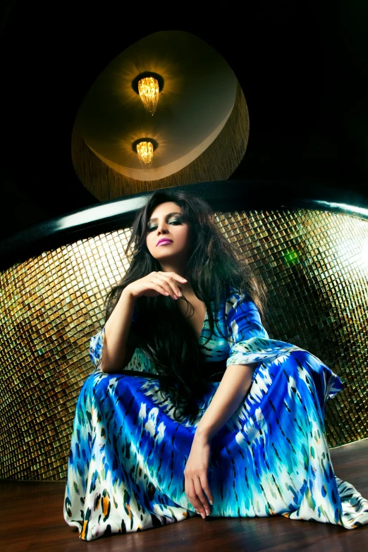 young woman sitting on floor wearing blue dress