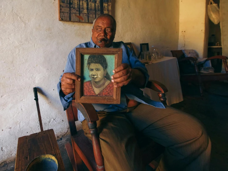 a man with a picture frame holding a small portrait