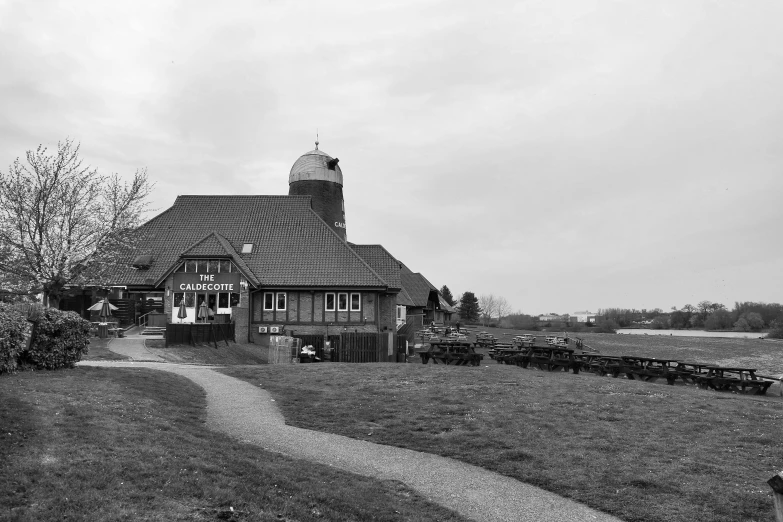 an old barn in the country with some people