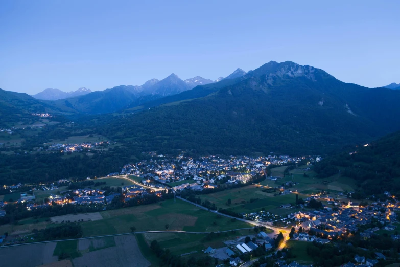 an aerial view of a town near mountains