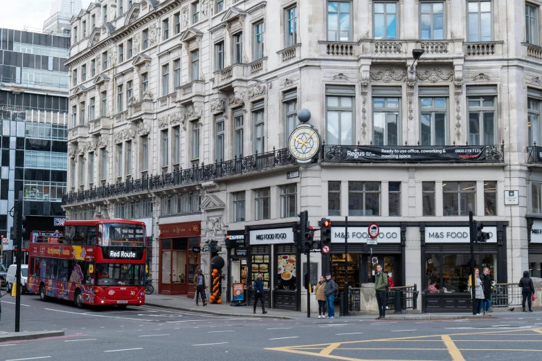 two red double decker buses parked on the side of a street