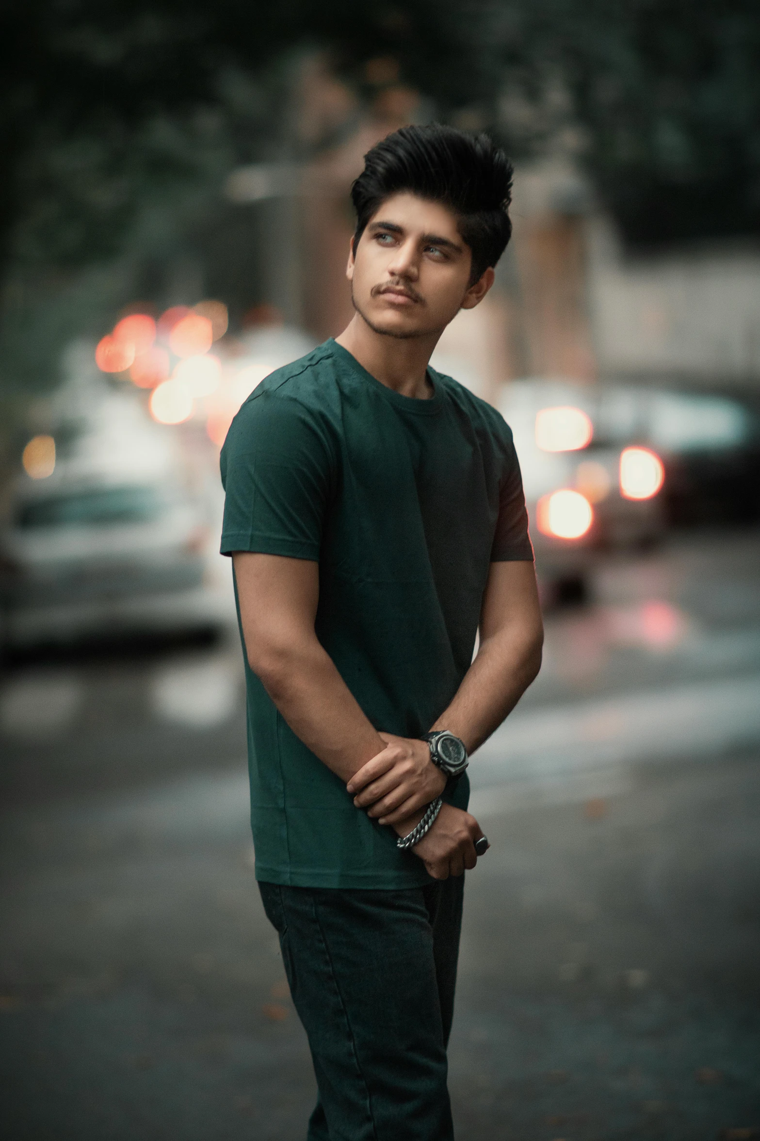 a young man standing on the side of a street