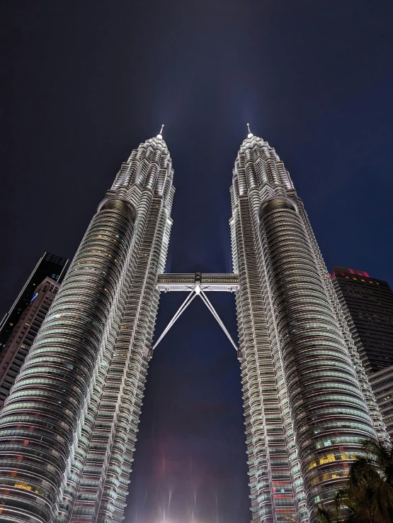 a view of two buildings from the bottom down at night